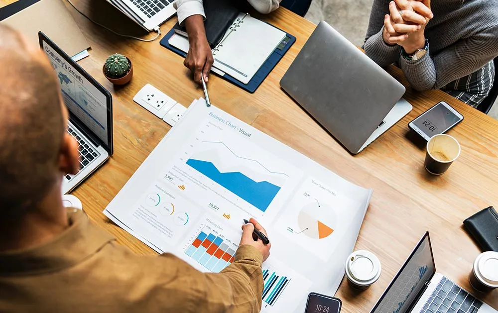 Business team reviewing financial charts around a table
