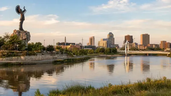 Wichita skyline, Keeper of the Plains statue, and Arkansas River at sunset